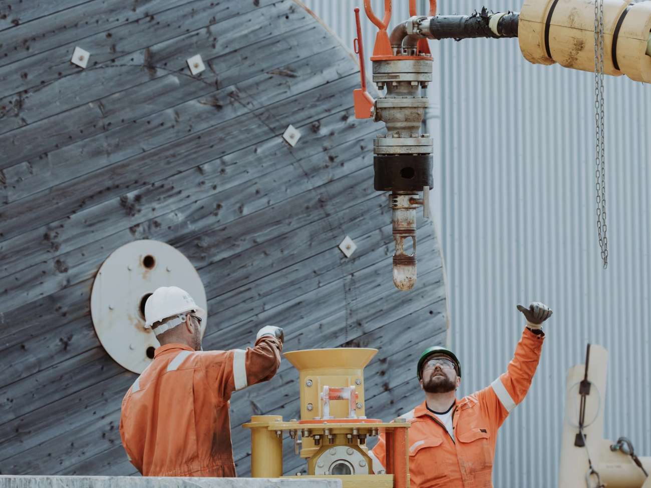 Two people in boiler suits moving subsea equipment