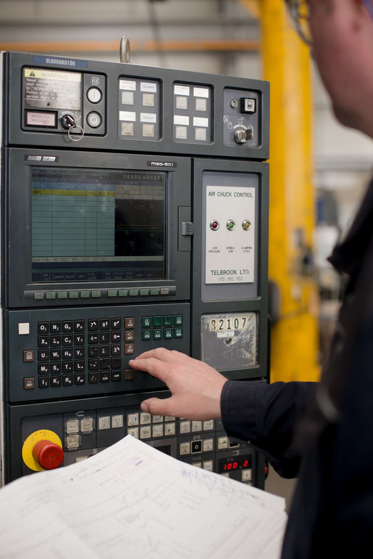 Person handling an industrial electronic device with multiple buttons and a small display